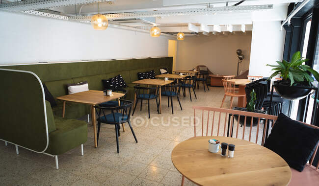 Gesamtansicht eines leeren Cafés, in dem Salz und Zucker auf einem Tisch liegen, im Hintergrund ein großes Sofa — Stockfoto