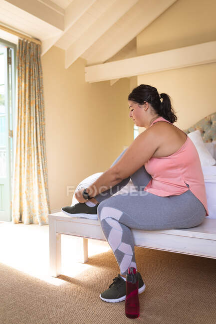 Femme vlogger caucasienne à la maison dans sa chambre, se préparant à démontrer des exercices pour son blog en ligne. Distance sociale et isolement personnel en quarantaine. — Photo de stock