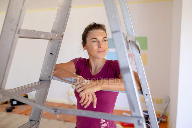 Caucasian woman spending time at home self isolating and social distancing in quarantine lockdown during coronavirus covid 19 epidemic, taking a break while renovating her home. — Stock Photo