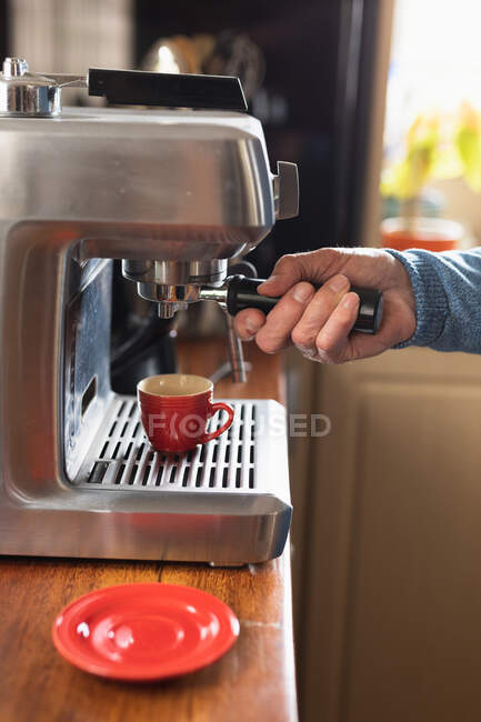 Seitenansicht Nahaufnahme der Hand eines Mannes, der sich zu Hause entspannt und Kaffee zubereitet, um ihn in einer Espressomaschine zu verwenden — Stockfoto