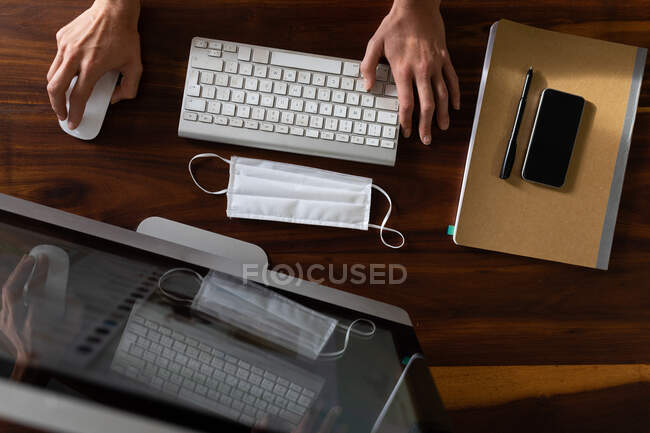 Overhead view of woman spending time at home, standing by her desk and working using her computer. Social distancing and self isolation in quarantine lockdown. — Stock Photo