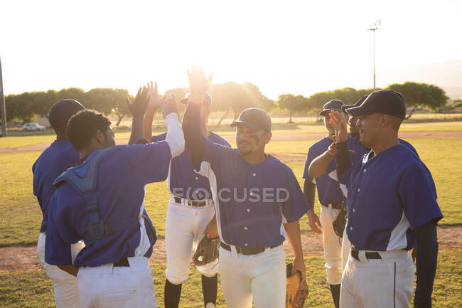Jugadores de béisbol haciendo cincos altos en el campo - foto de stock