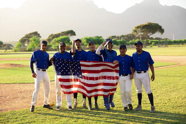 Jogadores de beisebol em linha com uma bandeira americana — Fotografia de Stock