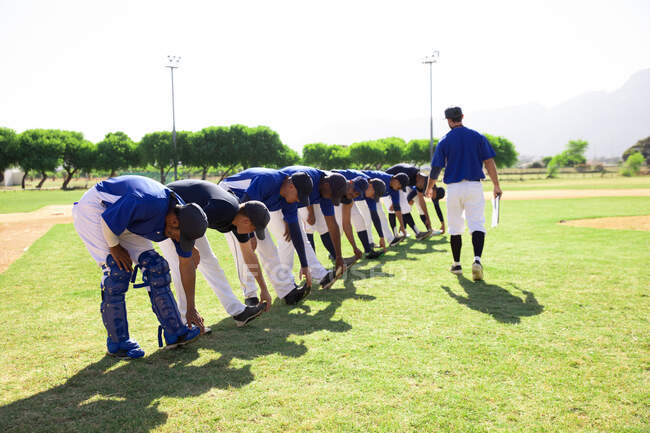 Jogadores de beisebol se alongando na linha — Fotografia de Stock
