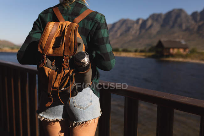 Rückansicht Mittelteil einer Frau, die bei einem Ausflug in die Berge Spaß hat, auf einem Kabinenbalkon steht und die Aussicht genießt, an einem sonnigen Tag — Stockfoto