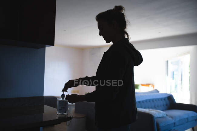 Silueta de una mujer caucásica distanciamiento social en casa durante el bloqueo del Coronvirus - foto de stock