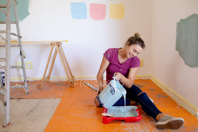 Mulher em Distanciamento Social pintando as paredes de sua casa com seus cães — Fotografia de Stock