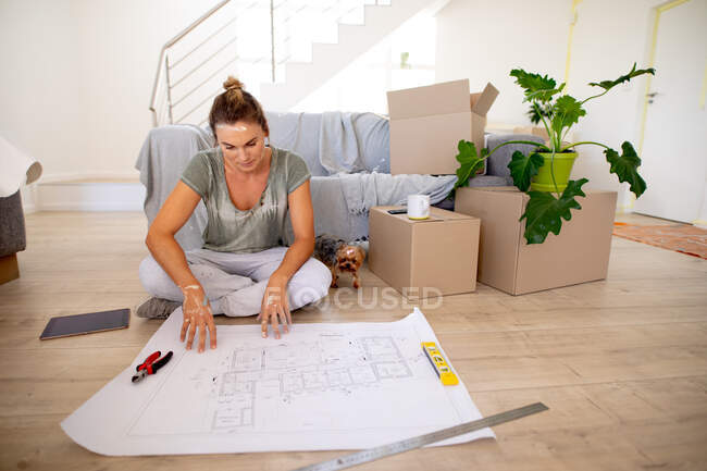 Frauen in sozialer Distanz sitzen auf dem Boden und prüfen einen Plan — Stockfoto