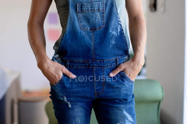 Mid section of woman wearing blue jeans dungarees, spending time at home self isolating and social distancing in quarantine lockdown during coronavirus covid 19 epidemic, taking a break while doing DIY. — Stock Photo