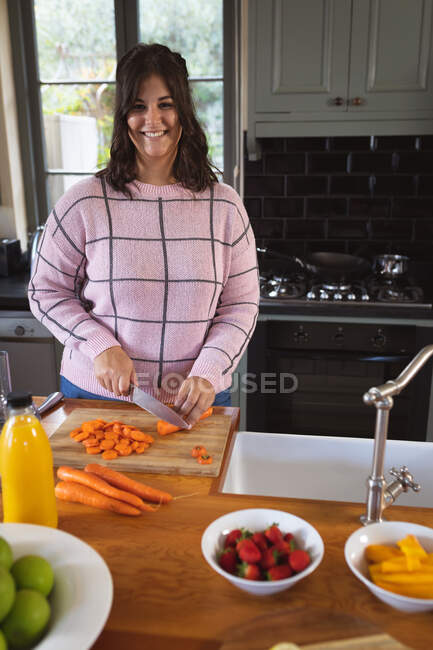 Vlogger feminino caucasiano feliz em casa em sua cozinha, demonstrando a preparação de receitas de alimentos para seu blog online. Distanciamento social e auto-isolamento em quarentena . — Fotografia de Stock