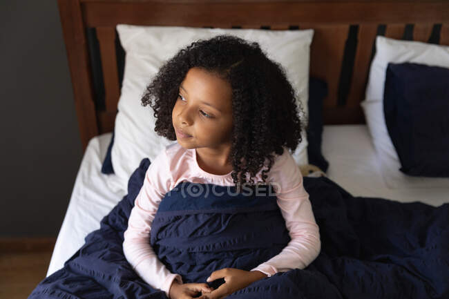 Menina afro-americana acordando em seu quarto pai em uma manhã ensolarada, durante o distanciamento social em casa durante o bloqueio de quarentena . — Fotografia de Stock