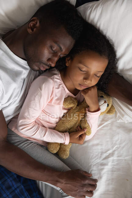 African American girl and her father social distancing at home during quarantine lockdown, spending time together, embracing while sleeping. — Stock Photo