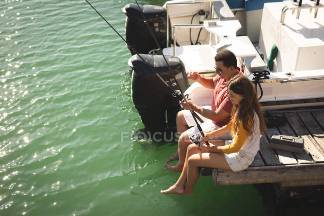 Un uomo caucasico e sua figlia adolescente in possesso di canne da pesca e parlando — Foto stock