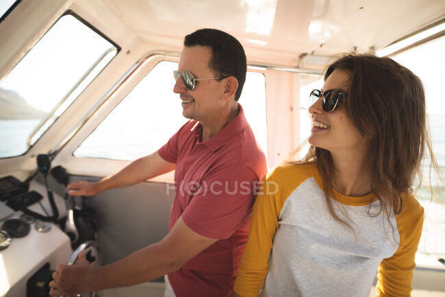 Белый мужчина и его дочь-подросток стоят на лодке — стоковое фото