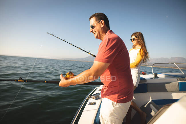 Un uomo caucasico e sua figlia adolescente in possesso e utilizzando canne da pesca — Foto stock