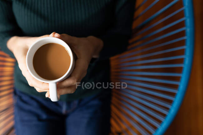 Mid section of woman spending time at home, drinking coffee. Lifestyle at home isolating, social distancing in quarantine lockdown during coronavirus covid 19 pandemic. — Stock Photo
