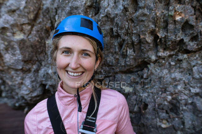 Porträt einer kaukasischen Frau, die die Zeit in der Natur genießt, Reißverschlussausrüstung trägt und an einem sonnigen Tag in den Bergen lächelt. Spaßiges Abenteuerwochenende. — Stockfoto