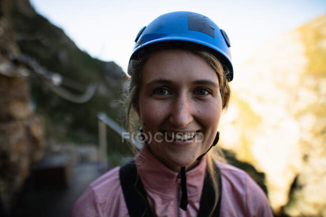 Portrait de femme caucasienne appréciant le temps dans la nature, portant un équipement de tyrolienne, souriant par une journée ensoleillée dans les montagnes. Fun week-end aventure vacances. — Photo de stock