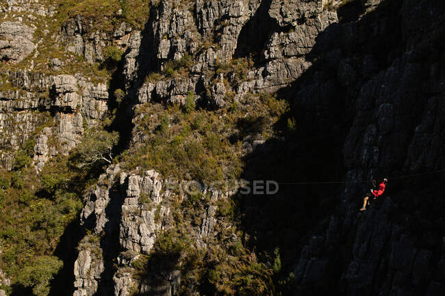 Seitenansicht des kaukasischen Mannes, der die Zeit in der Natur genießt, Reißverschlussfutter, Reißverschlussausrüstung trägt, an einem sonnigen Tag in den Bergen — Stockfoto