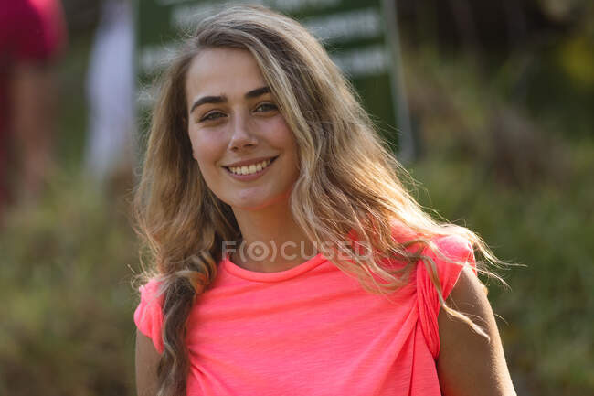 Retrato de la feliz mujer caucásica voluntaria de conservación limpiando el bosque en el campo, sonriendo a la cámara. Ecología y responsabilidad social en el medio rural. - foto de stock