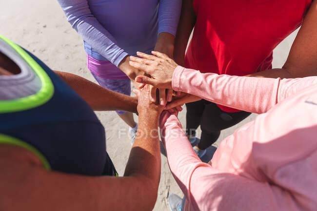 Close up de um grupo de amigas caucasianas gostando de se exercitar em uma praia em um dia ensolarado, se unindo e de pé. — Fotografia de Stock
