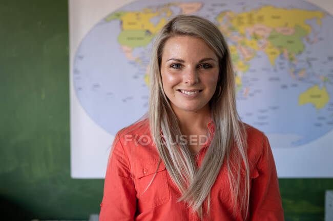 Retrato de uma professora caucasiana com cabelo loiro em pé em uma sala de aula da escola primária. Educação primária distanciamento social segurança sanitária durante Covid19 pandemia de coronavírus. — Fotografia de Stock