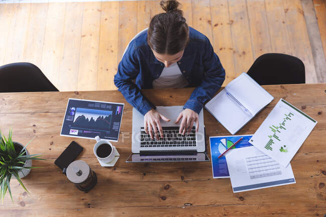 Кавказька жінка проводить час удома, сидячи за столом за допомогою ноутбука, працюючи з дому, друкуючи. Соціальна дистанція в Ковиді 19 Коронавірус карантин. — стокове фото