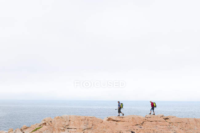 Старша пара проводить час у природі разом, гуляючи в горах біля моря. здоровий спосіб життя пенсійна діяльність . — стокове фото