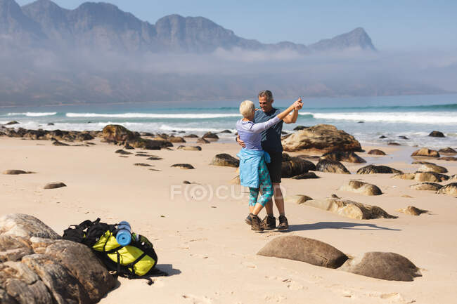 Senior couple spending time in nature together, walking on the beach, dancing. healthy lifestyle retirement activity. — Stock Photo