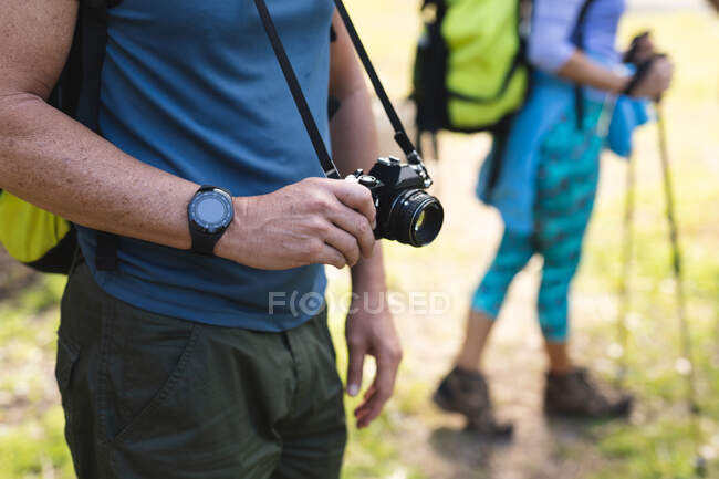 Coppia trascorrere del tempo nella natura insieme, passeggiare in montagna, tenere in mano una macchina fotografica. — Foto stock