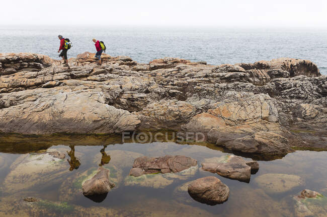 Senior couple spending time in nature together, walking in the mountains, by the sea. healthy lifestyle retirement activity. — Stock Photo