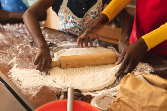 Mid section of african american mother and daughter baking in the kitchen at home. christmas festivity tradition celebration concept — Stock Photo