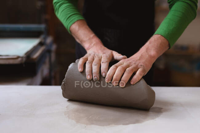 Close up of male potter working in pottery studio. working at a working table. small creative business during covid 19 coronavirus pandemic. — Stock Photo