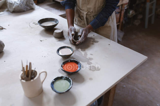 Ceramista donna che lavora nello studio di ceramica. lavorare ad un tavolo di lavoro. piccola attività creativa durante covid 19 coronavirus pandemia. — Foto stock