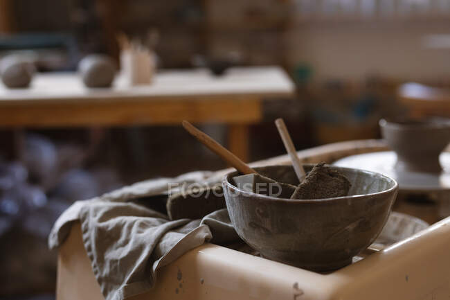 Инструменты Поттера лежат на рабочем столе в мастерской керамики. малый творческий бизнес во время пандемии коронавируса ковида 19. — стоковое фото