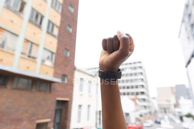 Femme afro-américaine serrant son poing dans une rue de la ville pendant une pandémie de coronavirus covid 19. — Photo de stock