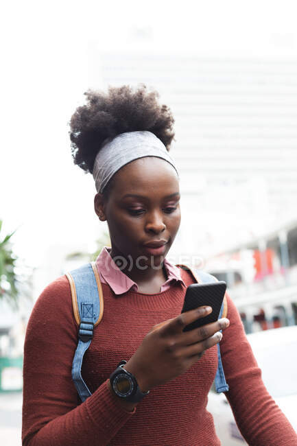 Портрет африканської американки, яка користується смартфоном на вулиці і навколо в місті під час пандемії коронавірусу.. — стокове фото
