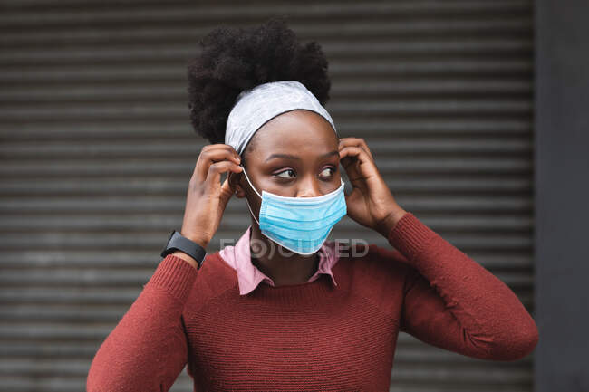 Ritratto di donna afroamericana che distoglie lo sguardo per strada in giro per la città durante la pandemia di coronavirus covid 19. — Foto stock