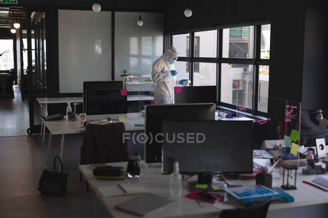 Health worker wearing protective clothes cleaning office using disinfectant. cleaning and disinfection infection prevention and control of covid-19 epidemic — Stock Photo