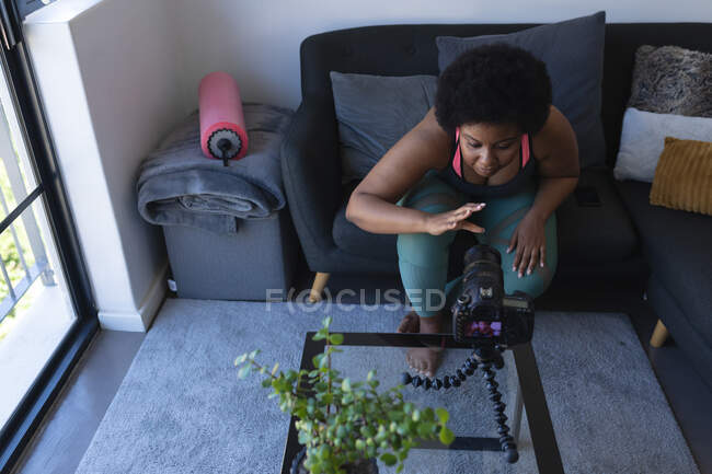 Afroamerikanische Vloggerin bei der Aufnahme eines Videos. über Sport. Selbstisolation Technologie Kommunikation zu Hause während Coronavirus covid 19 Pandemie. — Stockfoto