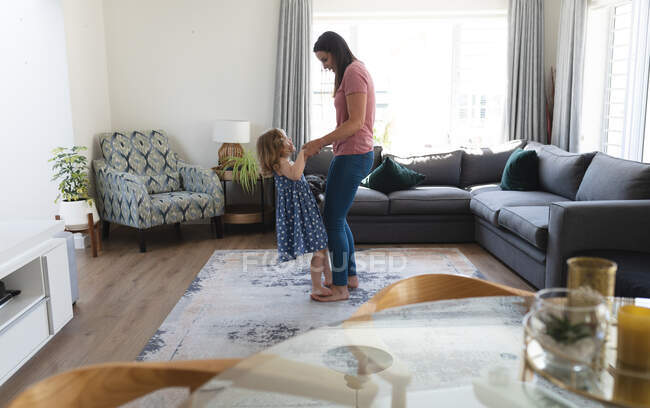 Kaukasische Mutter und Tochter haben Spaß beim Tanzen im Wohnzimmer. Genießen Sie die Zeit zu Hause während Coronavirus covid 19 pandemischen Lockdown. — Stockfoto