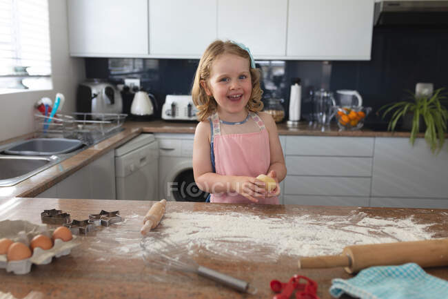 Menina caucasiana se divertindo cozimento na cozinha. desfrutando de tempo de qualidade em casa durante coronavírus covid 19 bloqueio pandêmico. — Fotografia de Stock