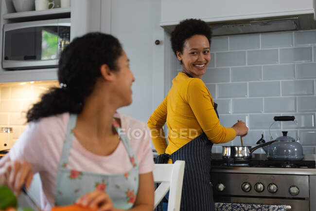 Змішана гоночна лесбійська пара готує їжу на кухні. самоізоляція якість сімейного часу вдома разом під час пандемії коронавірусу 19 . — стокове фото