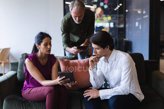 Homme d'affaires et femme d'affaires divers portant des appareils électroniques au bureau. technologie et équipe travaillant sur le lieu de travail. — Photo de stock