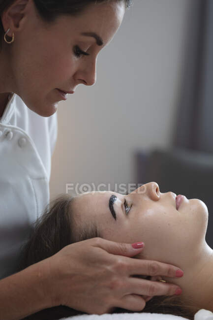 Mulher branca deitada enquanto esteticista pinta as sobrancelhas. cliente desfrutando de tratamento em um salão de beleza. — Fotografia de Stock