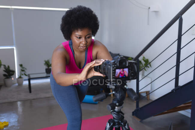 Una vlogger afroamericana che registra un video. tecnologia di autoisolamento comunicazione a casa durante coronavirus covid 19 pandemia. — Foto stock