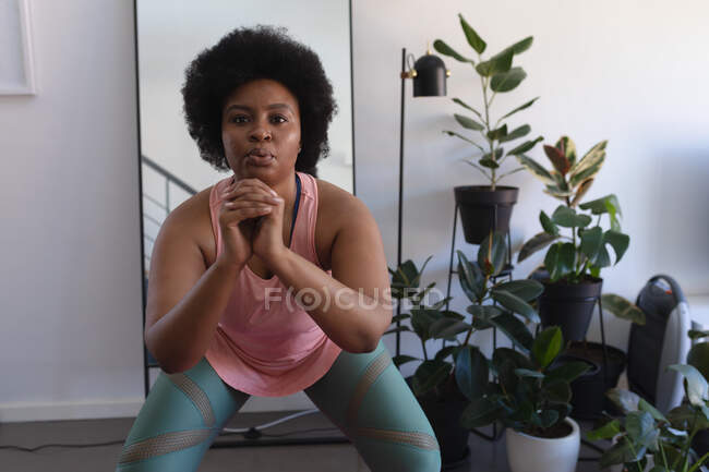 Portrait of african american woman in sportswear working out. self isolation fitness at home during coronavirus covid 19 pandemic. — Stock Photo