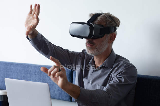 Caucasian businessman sitting using vr googles and laptop in modern office. business modern office workplace technology. — Stock Photo