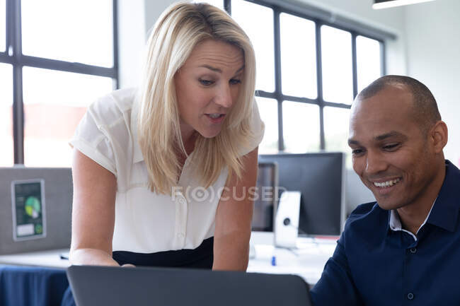Різноманітні бізнесмени сидять за допомогою ноутбука, який розмовляє в сучасному офісі. бізнес сучасні технології офісного робочого місця . — стокове фото