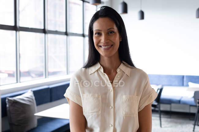 Portrait of mixed race businesswoman standing looking at camera and smiling in modern office. business modern office workplace technology. — Stock Photo